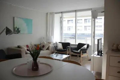 a living room with a vase of flowers on a table at Strandlicht in Egmond aan Zee