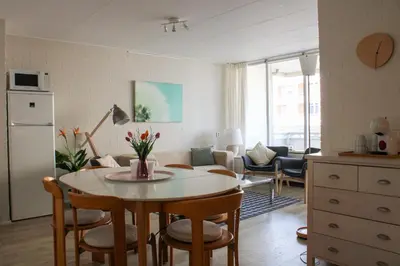 a kitchen and living room with a table and chairs at Strandlicht in Egmond aan Zee