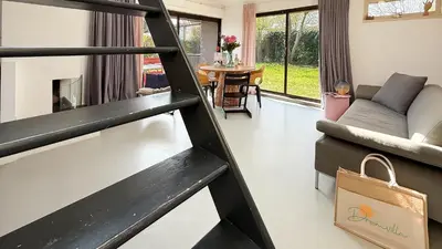 a living room with a couch and a table at Het Duinhuisje by Droomvilla in Egmond aan den Hoef