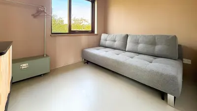 a couch in a living room with a window at Het Duinhuisje by Droomvilla in Egmond aan den Hoef