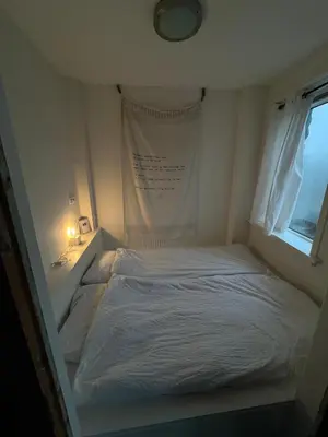 a bedroom with a white bed with a window at Close to the beach modern appartement Oranje Boven in Zandvoort