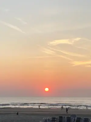 a sunset at the beach with people on the beach at Close to the beach modern appartement Oranje Boven in Zandvoort
