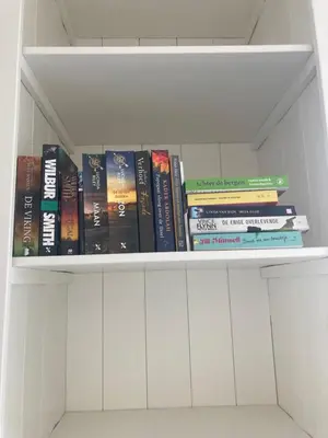 a book shelf filled with lots of books at Close to the beach modern appartement Oranje Boven in Zandvoort