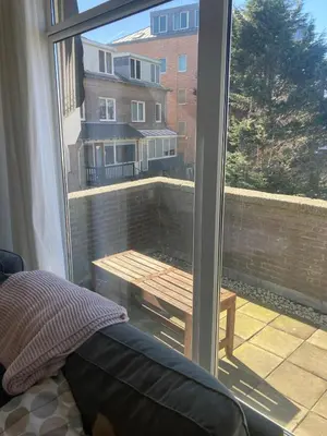 a view of a balcony with a table and a window at Close to the beach modern appartement Oranje Boven in Zandvoort