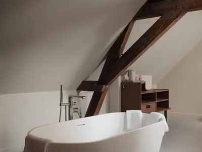 a white bath tub in a room with a attic at Conscious Hotel Oudegracht in Utrecht