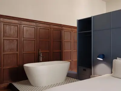 a bedroom with a bath tub next to a bed at Conscious Hotel Oudegracht in Utrecht