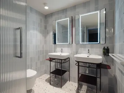 a bathroom with two sinks and two mirrors at Conscious Hotel Oudegracht in Utrecht