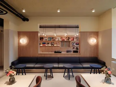 a waiting room with a couch and tables at Conscious Hotel Oudegracht in Utrecht