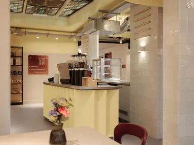 a kitchen with a counter and a table with a vase of flowers at Conscious Hotel Oudegracht in Utrecht