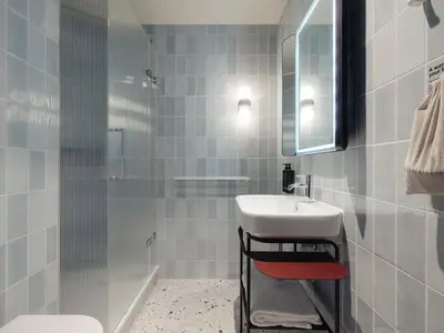 a white bathroom with a sink and a shower at Conscious Hotel Oudegracht in Utrecht