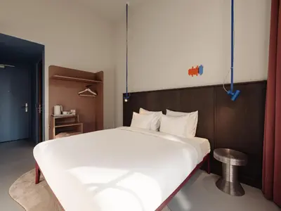 a bedroom with a large white bed and a table at Conscious Hotel Oudegracht in Utrecht