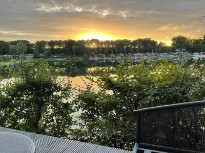 a view of a body of water with the sunset at Luxe nieuwbouw chalet aan het water in Hoevelaken