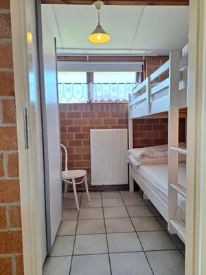 a room with two bunk beds and a chair at Rekerlanden 210 in Schoorldam