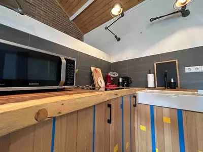 a kitchen with a microwave on a wooden counter at Sfeervol Overnachten in de Kerk in Amersfoort