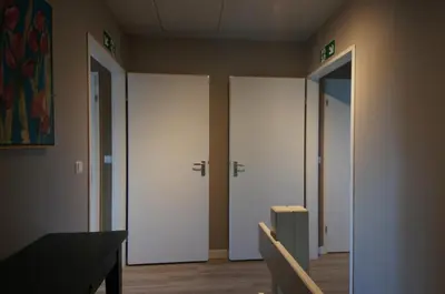 three doors in a room with a table and chairs at De Sas in Lisse in Lisse