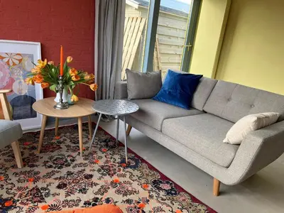 a living room with a couch and a table at Holiday Home in Noordwijkerhout near Lake in Noordwijkerhout