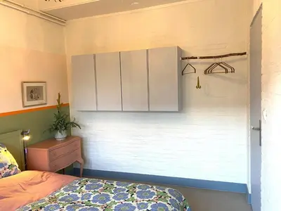 a bedroom with a bed and a white cabinet at Holiday Home in Noordwijkerhout near Lake in Noordwijkerhout