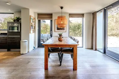 a kitchen with a wooden table in a room at Villa Koperwiek in Egmond aan den Hoef