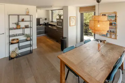 a kitchen and dining room with a wooden table and chairs at Villa Goudvink in Egmond aan den Hoef