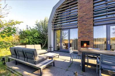a patio with a table and chairs and a fireplace at Villa Goudvink in Egmond aan den Hoef