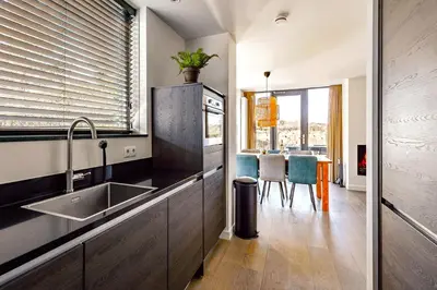 a kitchen with a sink and a table at Villa Goudvink in Egmond aan den Hoef