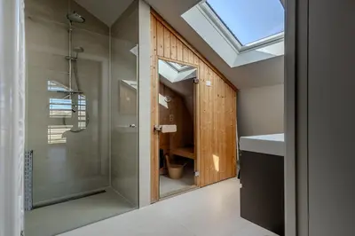 a bathroom with a shower and a glass shower backdoor at Villa Goudvink in Egmond aan den Hoef