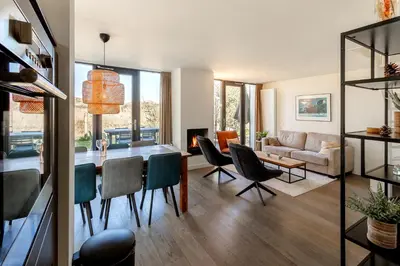 a dining room and living room with a table and chairs at Villa Goudvink in Egmond aan den Hoef