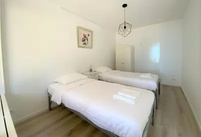 two beds in a room with white walls and wooden floors at Sterflat 33 - 