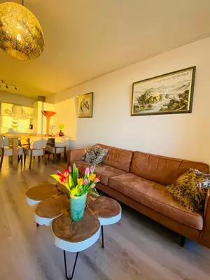 a living room with a brown leather couch and tables at Sterflat 33 - 