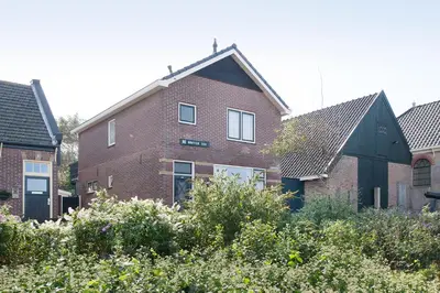 a red brick house with a black roof at De Groten Zes in Egmond aan Zee