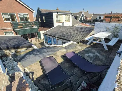 an overhead view of two chairs and a table on a roof at De Groten Zes in Egmond aan Zee
