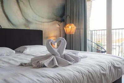 two swans sitting on top of a bed at Coastal Inn in Zandvoort