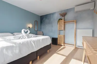 a bedroom with a bed and a blue wall at Coastal Inn in Zandvoort