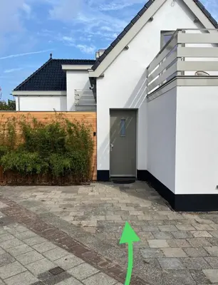 a white house with a green arrow pointing to it at Salty Breeze in Noordwijk