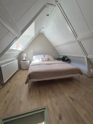a bedroom with a bed in the attic at Vlier aan zee in Katwijk aan Zee