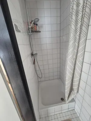 a bathroom with a shower with a shower curtain at Vlier aan zee in Katwijk aan Zee