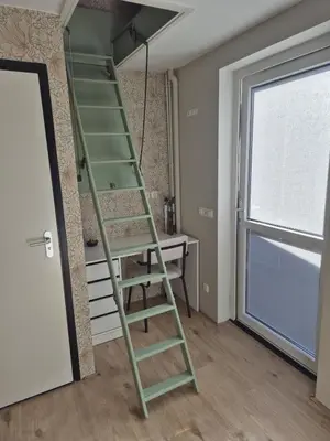 a green ladder in a room with a desk at Vlier aan zee in Katwijk aan Zee