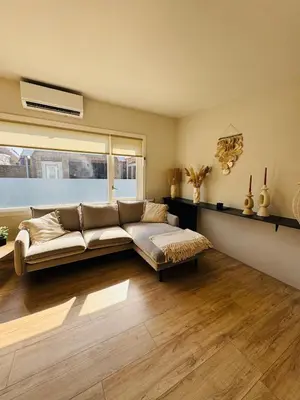 a living room with a couch and a large window at Willem's Beachhouse in Noordwijk