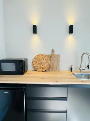 a kitchen counter with a microwave and a sink at Willem's Beachhouse in Noordwijk