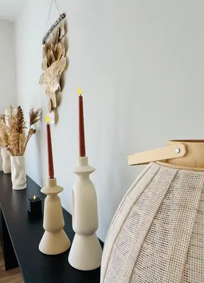 a table with three white vases on it at Willem's Beachhouse in Noordwijk