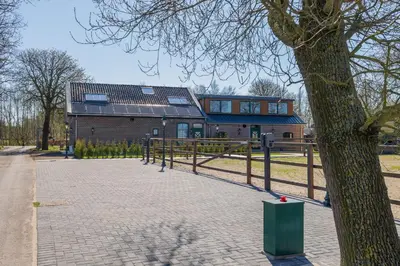 a house with a tree in front of it at Villa Meer en Duin in Noordwijkerhout