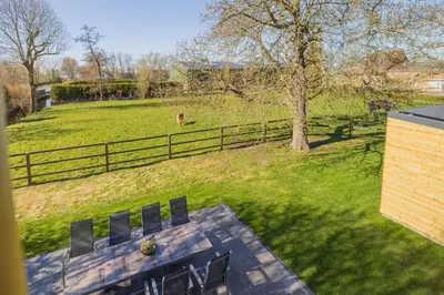 a view of a field with a fence and a bench at Villa Meer en Duin in Noordwijkerhout