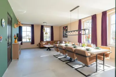 a dining room with a long table and chairs at Villa Meer en Duin in Noordwijkerhout