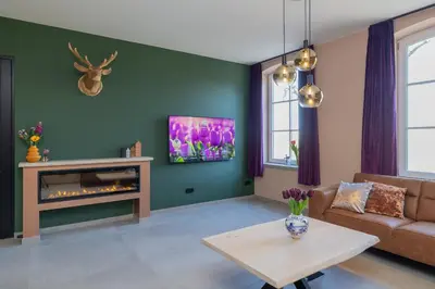 a living room with a couch and a fireplace at Villa Meer en Duin in Noordwijkerhout