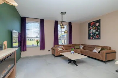 a living room with a couch and a table at Villa Meer en Duin in Noordwijkerhout