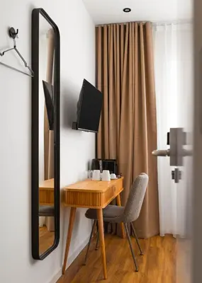 a room with a wooden table and a mirror at Limehome Utrecht Balijelaan in Utrecht
