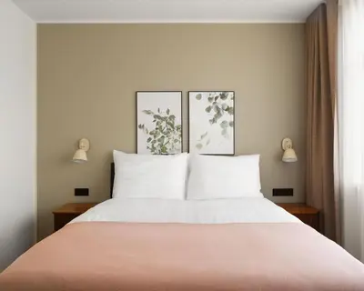 a bedroom with a large bed with two pictures on the wall at Limehome Utrecht Balijelaan in Utrecht