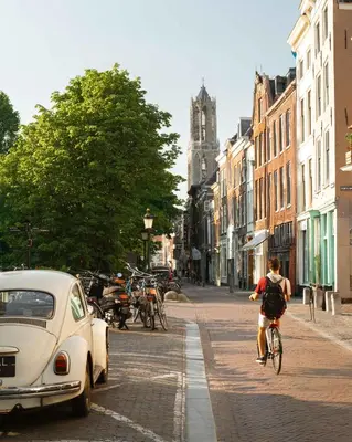 a person riding a bike down a city street at Limehome Utrecht Balijelaan in Utrecht