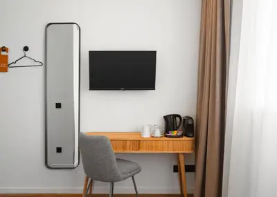 a desk with a chair and a television on a wall at Limehome Utrecht Balijelaan in Utrecht