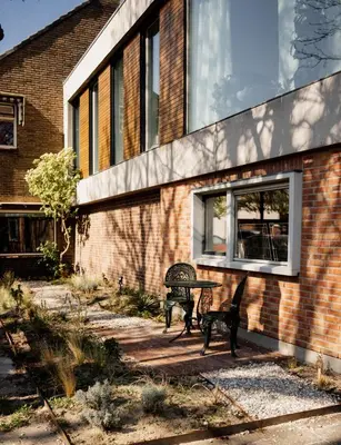 a patio with two benches and a table in front of a building at de Bunker Katwijk in Katwijk